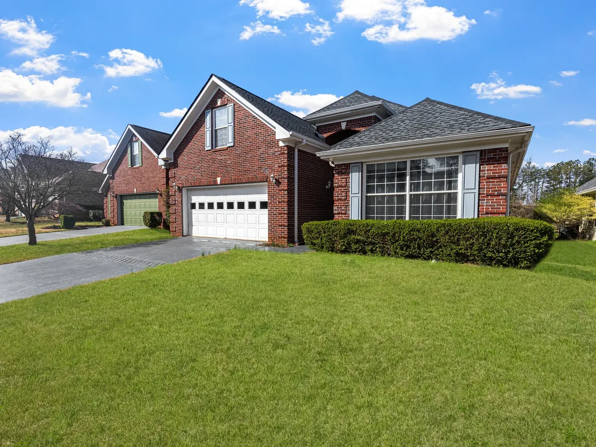 Freshly mowed green lawn behind a brick house