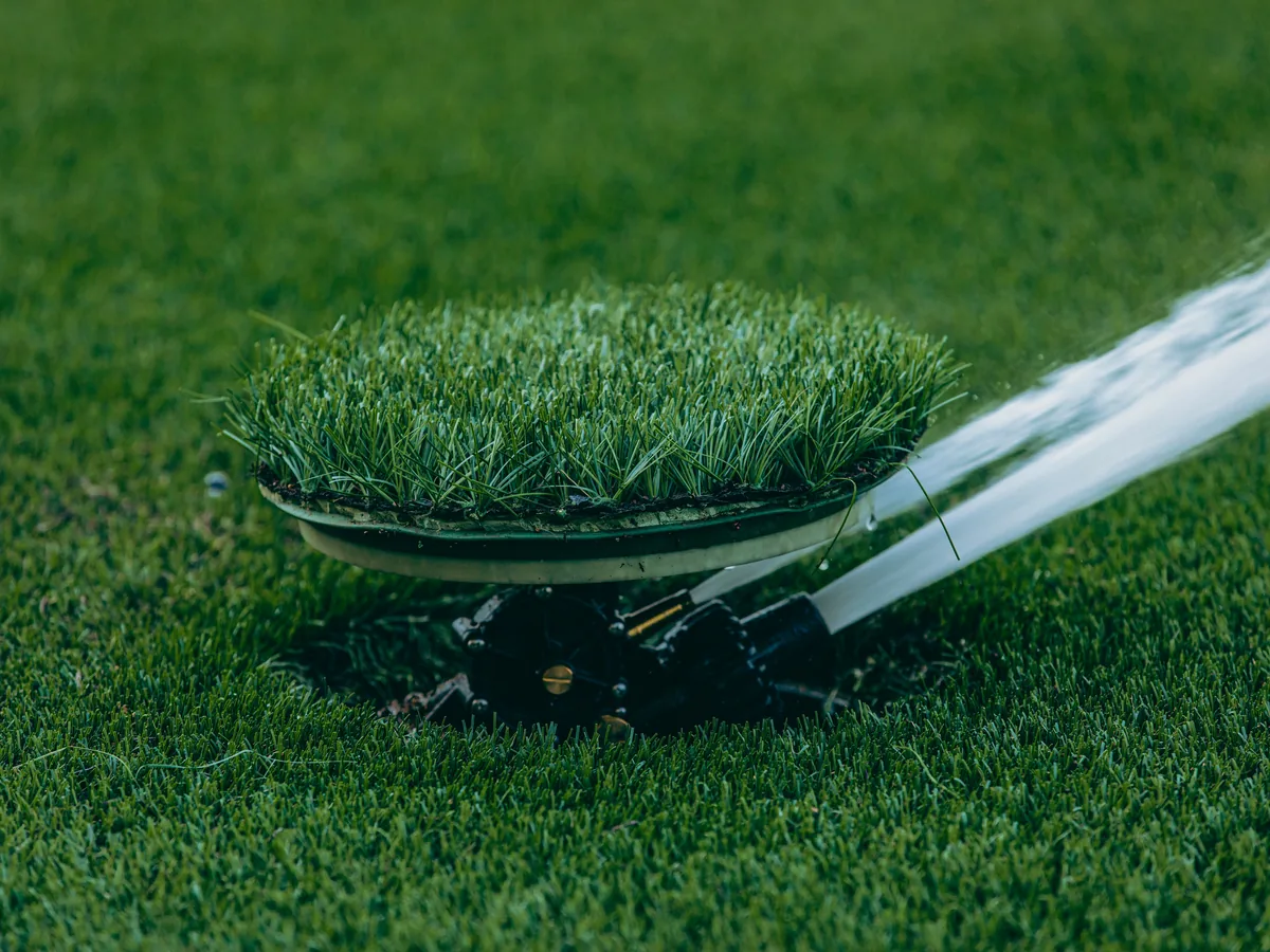 Sprinkler head spraying across a lawn
